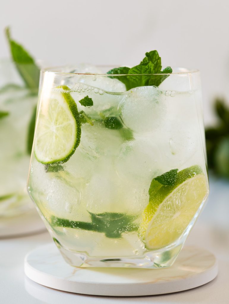 refreshing mojito mocktail in a tall glass with fresh mint leaves and lime slices.”