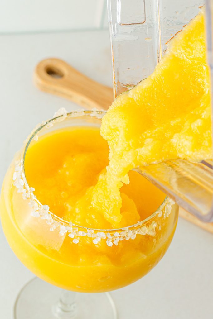 pouring frozen non-alcoholic mocktail into prepared glasses