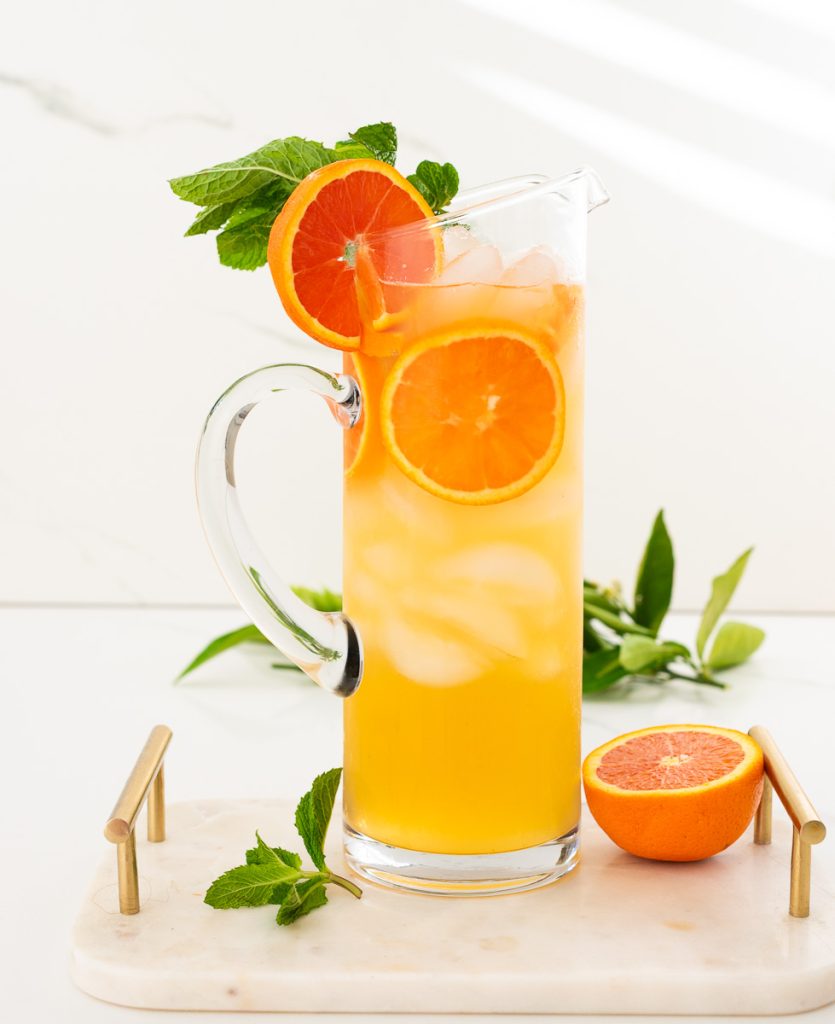 Huge pitcher of orange mojito mocktail with fresh mint 