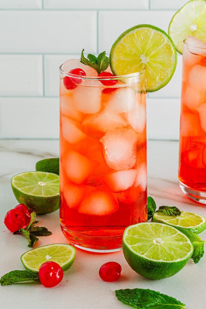 Tall glass of classic Shirley Temple Drink with Maraschino Cherries
