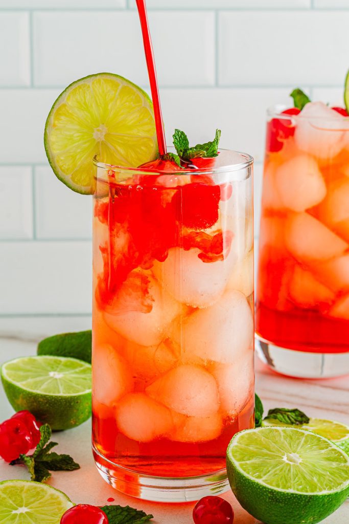 Pouring pomegranate syrup into ginger ale for Shirley Temple drink