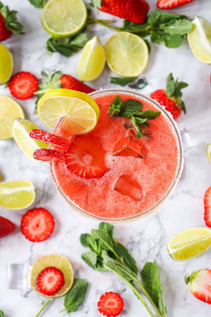 Large glass of strawberry mint mocktail with fresh lime slices