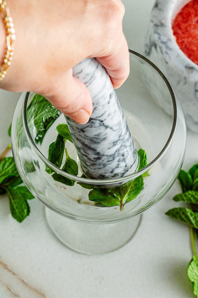 Muddling fresh mint for watermelon mocktail