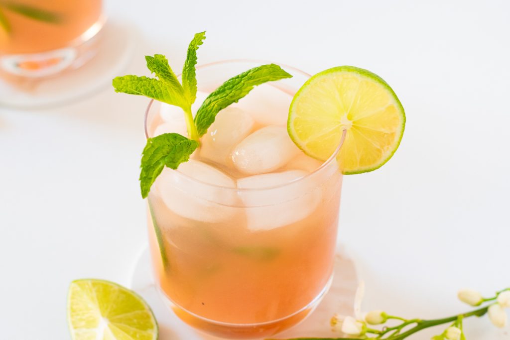 Guava mojito mocktail with sprig of mint and lime slice