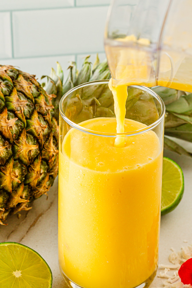 pouring alcohol free mangodrink into glass