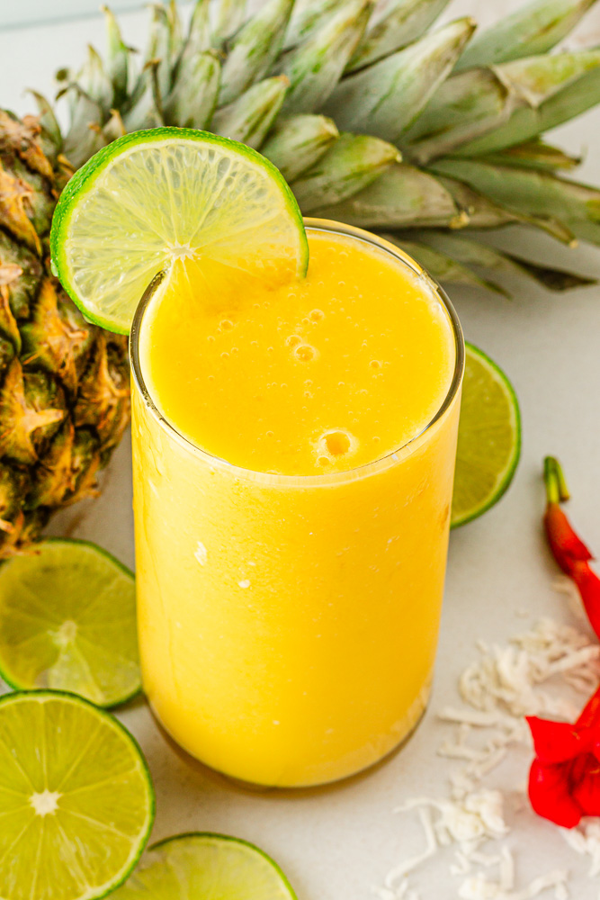 glass of mango colada with pineapple and lime