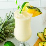 Tall glass of creamy Virgin Piña Colada mocktail with pineapple wedge
