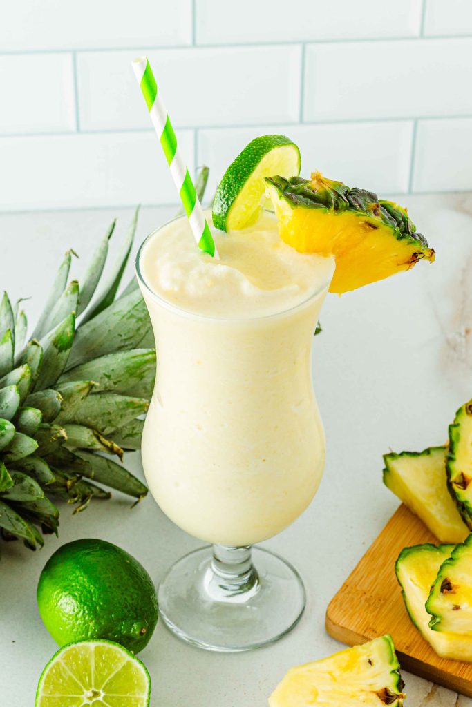 Tall glass of creamy Virgin Piña Colada mocktail with pineapple wedge 