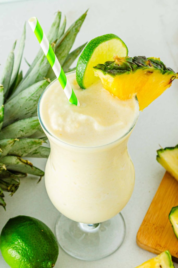 Glass of Virgin Pina Colada with green and white straw