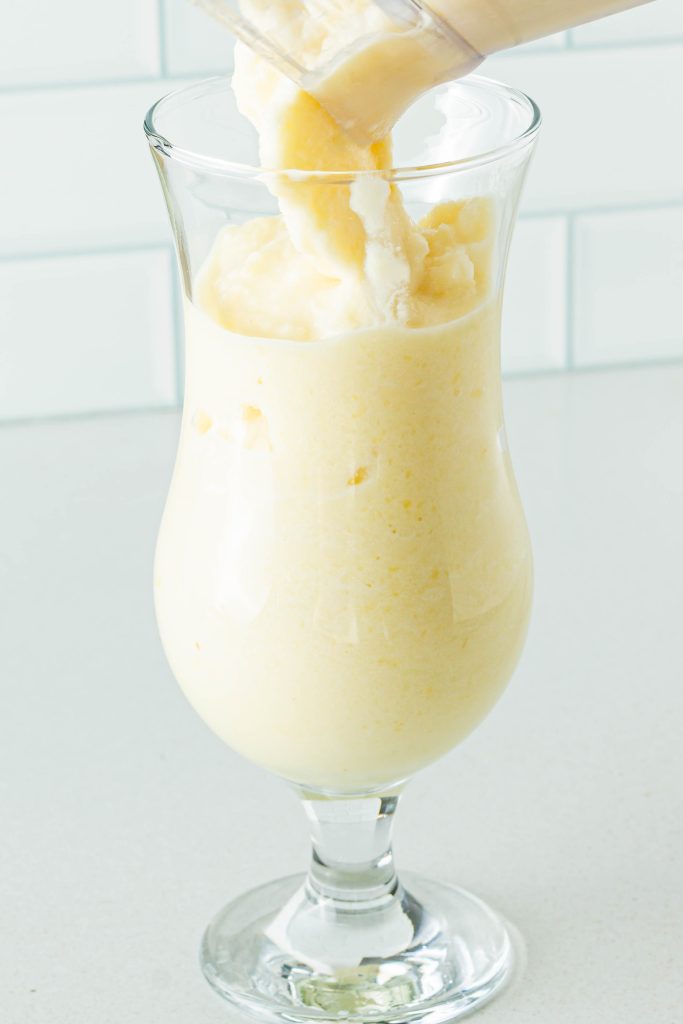 Pouring non-alcoholic pina colada into glass