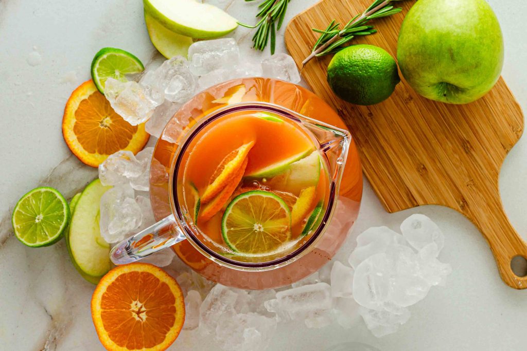 Pitcher of fruit punch with limes and ice