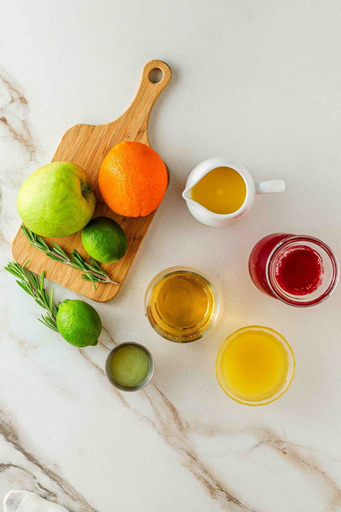 Cranberry, pineapple, and orange juices with ginger ale and fresh citrus slices ready for festive fruit punch