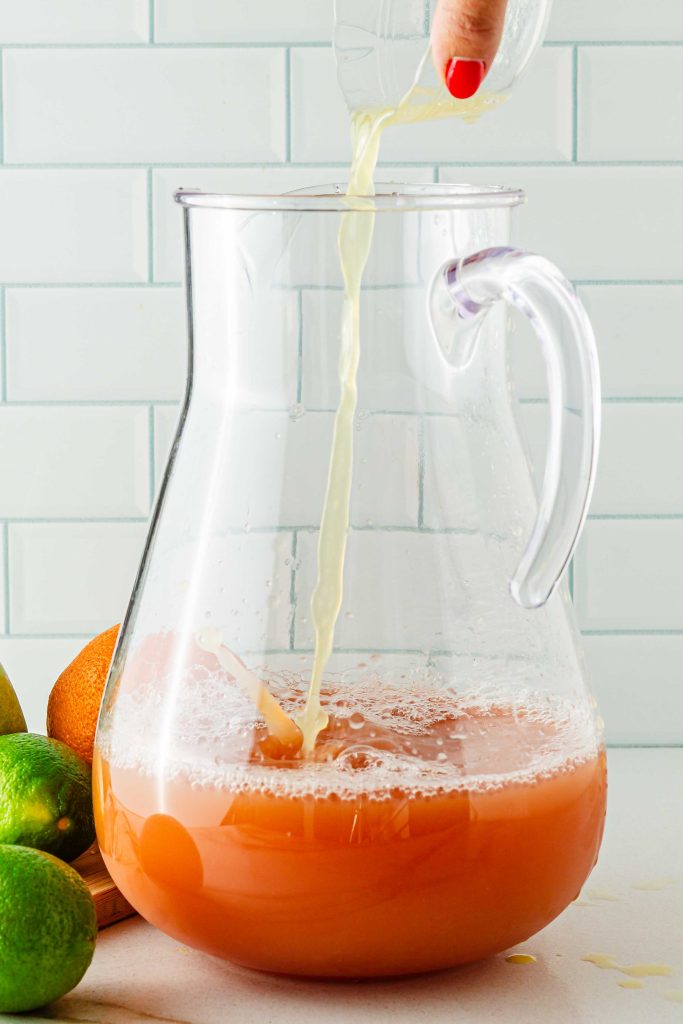 Adding pineapple juice and lime juice to pitcher