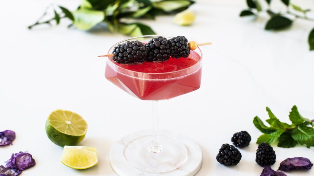 Jewel-toned blackberry mocktail topped with non-alcoholic sparkling wine