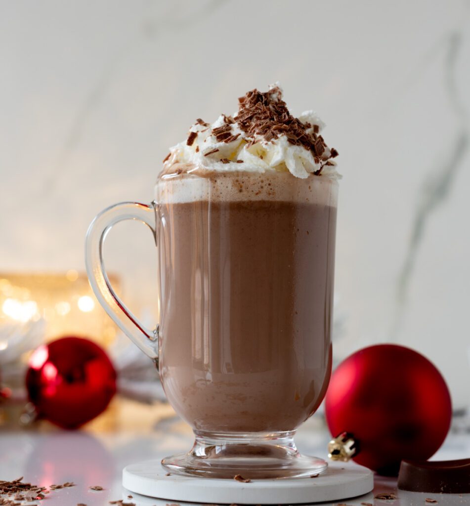 Glass of homemade hot chocolate with whipped cream and chocolate shavings
