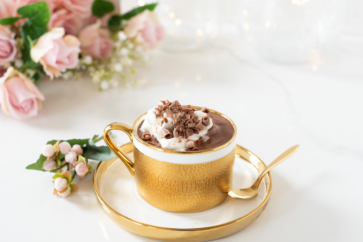 Cup of French Hot Cocoa in gold cup with whipped cream