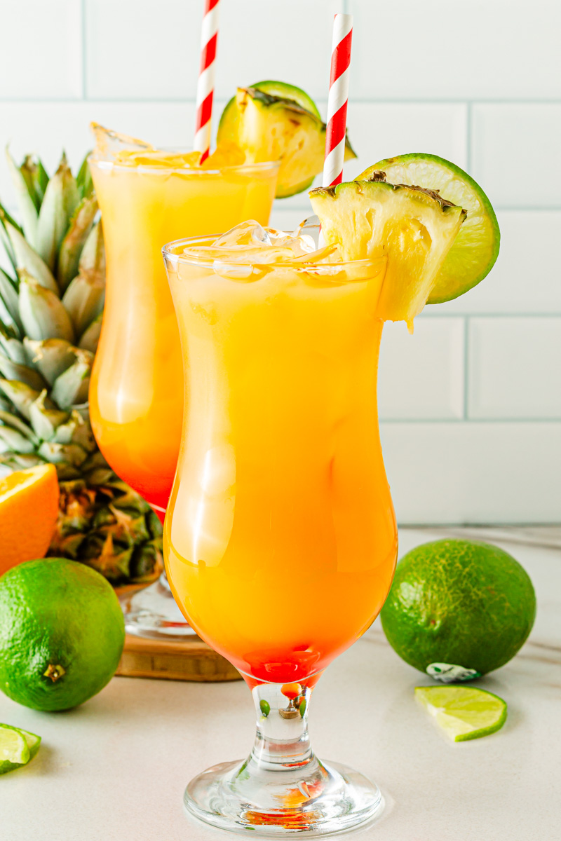 Tropical hurricane mocktail with pineapple juice, passion fruit syrup, citrus, and grenadine sunset layers