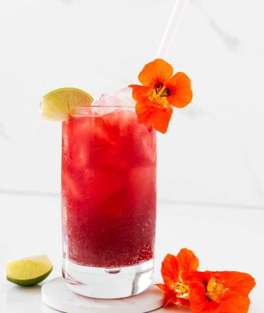 glass of strawberry mocktail with fresh edible flowers
