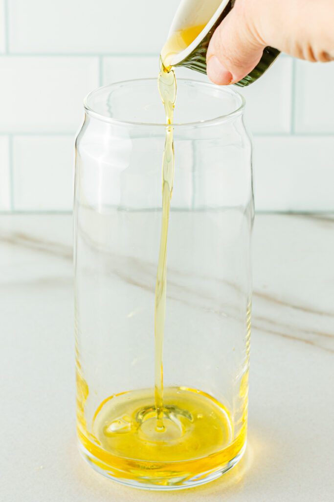 pouring juice into passionfruit mocktail 