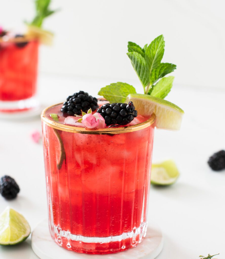 glass of blackberry mojito mocktail with fresh mint and lime