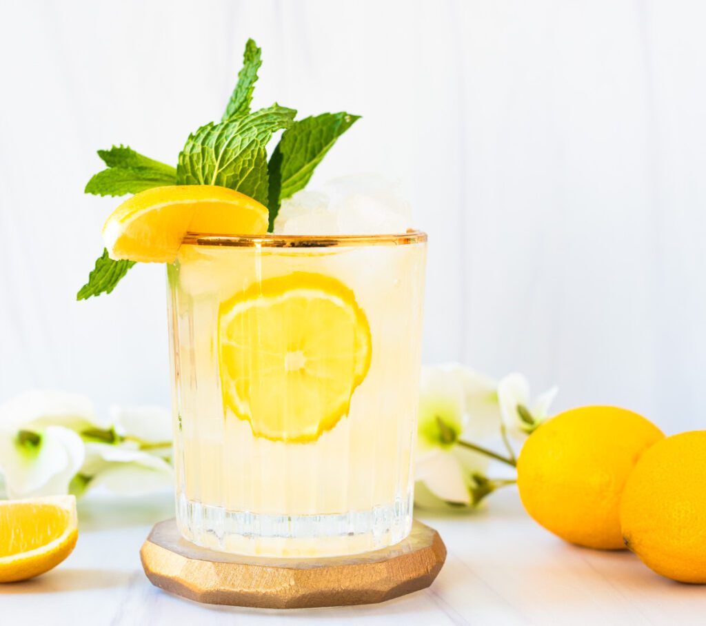 glass of lemon mocktail with fresh mint and bright yellow lemons