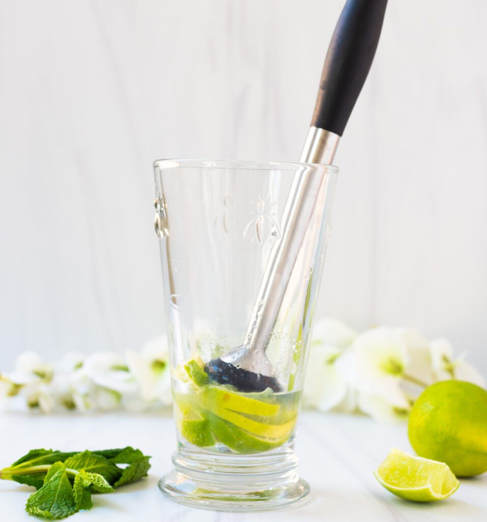 muddle limes in bottom of glass