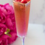 Tall champagne flute filled with a pink mocktail