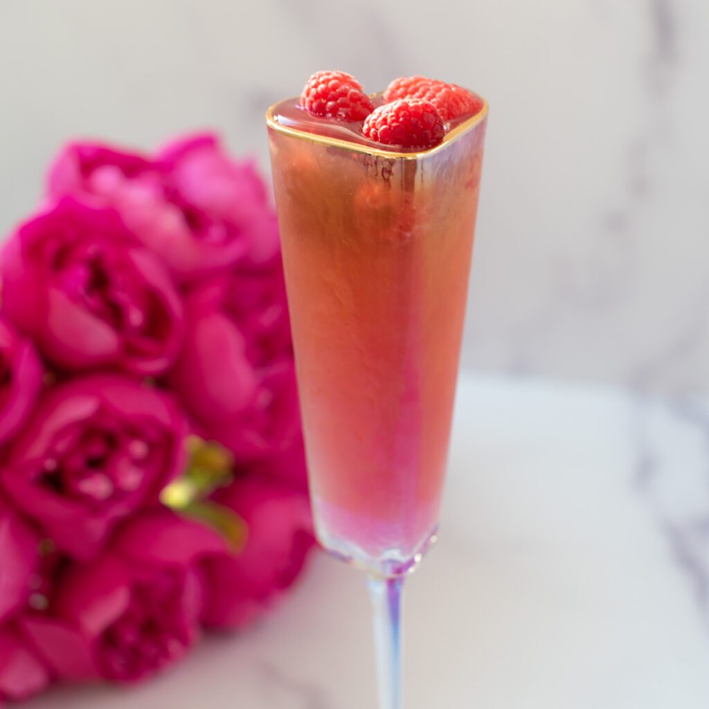 raspberry mocktail with sparkling bubbles, fresh raspberries, and citrus in a glass”