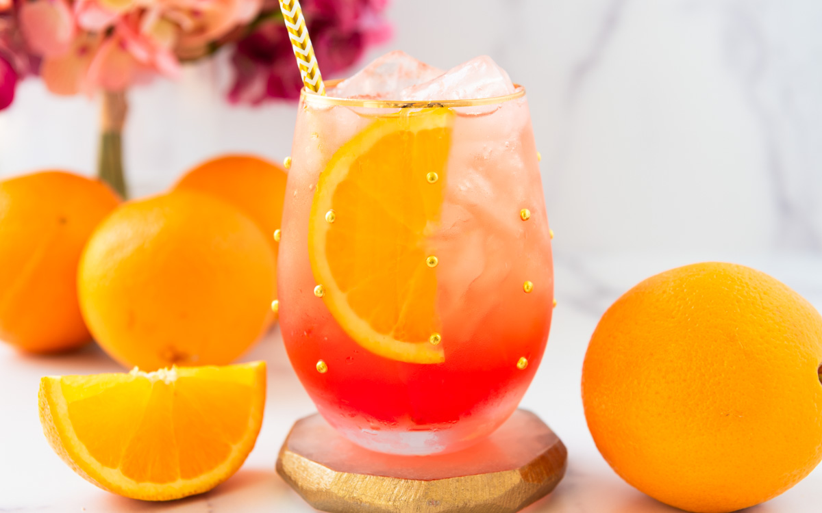 oranges and an Aperol spritz mocktail with flowers