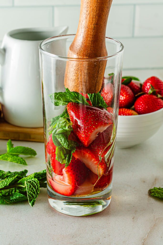 muddle strawberry mixture in tall glass