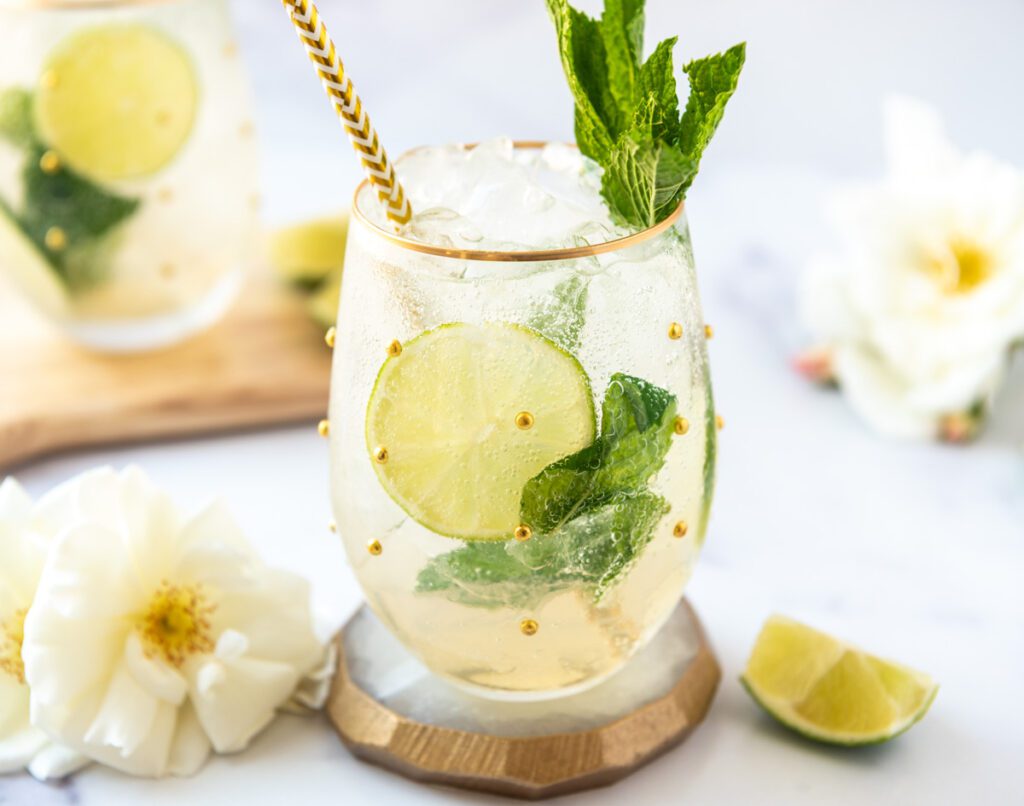 glass of Hugo Spritz Mocktail with fresh mint and limes