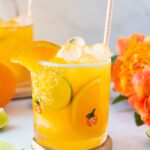 Glass of virgin tropical margarita mocktail with orange flowers and citrus