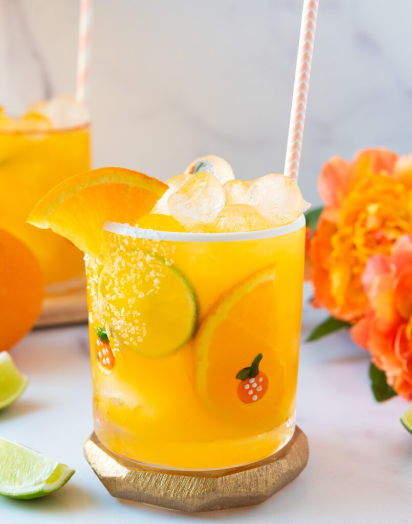 Glass of virgin tropical margarita mocktail with orange flowers and citrus
