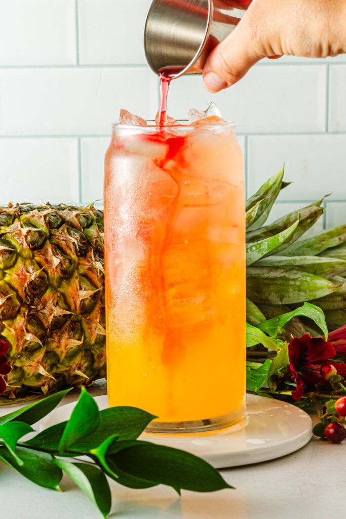 adding syrup to tropical mocktail